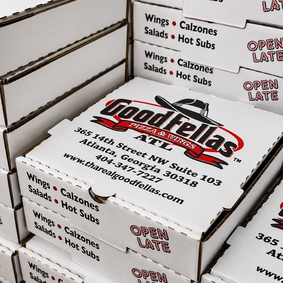 Stacked Goodfellas Pizza & Wings boxes display the Atlanta address, website, menu categories, and “Open Late” text.